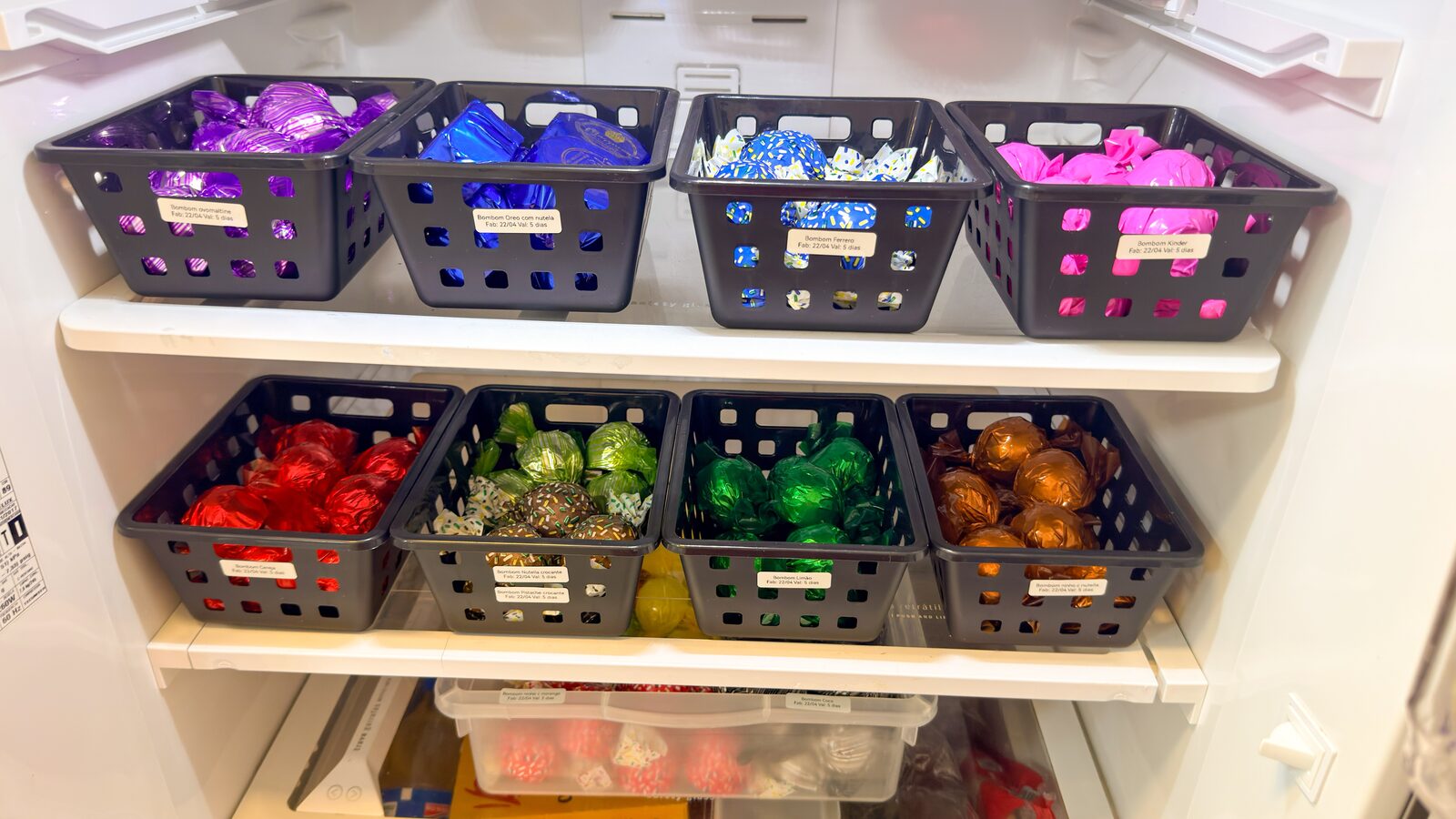 Geladeira com bombons organizados em cestos coloridos por sabor